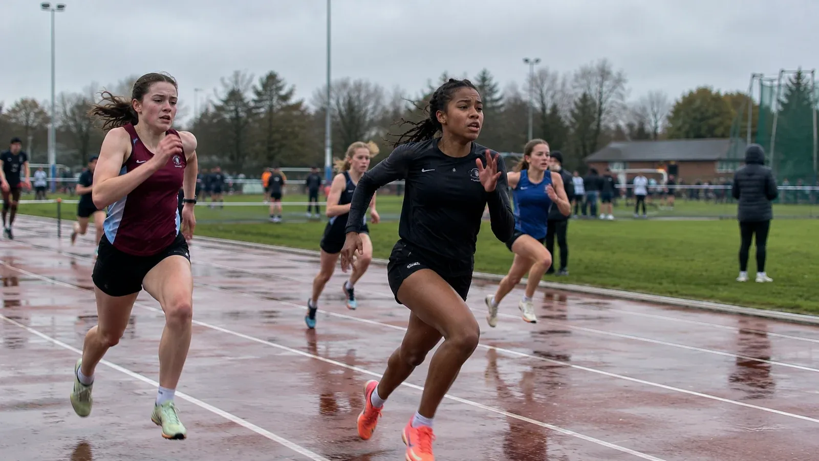 Young runners sprinting during a rainy community athletics event